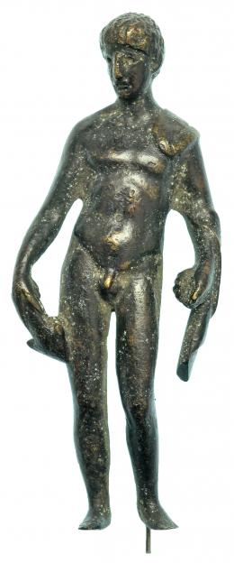 GRECIA. Época Helenística. Bronce. Figura  de atleta sujetando clámide y haltera. Altura: 9,6 cm. Incluye peana. Procedente de colección privada española años 2000.