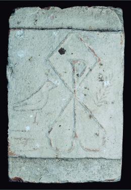 PERÍODO PALEOCRISTIANO. Placa decorativa (IV-V d.C.). Barro cocido. Con decoración de Crismón terminado en Alfa y Omega en apéndices. Pájaro y ramo a los lados. Dimansiones 22,3 x 34,2 cm.