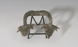 MUNDO ANTIGUO. Greco-Romano. Asa (¿de crátera?) con decoración distal vegetal. Bronce. Longitud 16,3 cm.