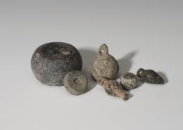 ROMA. Imperio Romano. Lote de seis objetos (I-IV d.C.). Bronce y piedra pulimentada. Dos colgantes en forma de bellota, cuatro ponderales: con orificio cuadrangular central, otro epigrafíado con IOB, otro con arandela superior y otro pulimentado. Altura 0,6-3,0 cm. Diámetro 1,3-3,5 cm. 