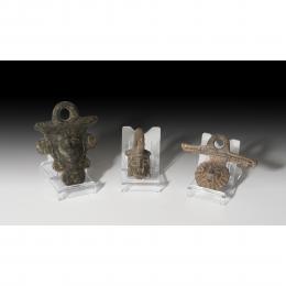 ROMA. Imperio Romano. Lote de tres apliques de asa de sítula (I-III d.C.). Bronce. Con representación frontal masculina barbada. Altura 5,2-8,2 cm.