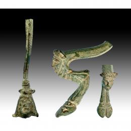 ROMA. Imperio Romano. Lote de dos objetos (II-IV d.C.). Bronce. Pie / soporte de trípode con representación de cabeza de Sátiro y asa de jarro con representación de cabeza masculina. Altura: 8,6 y 13,2 cm. 
