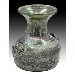 2729  -  ÁRABE-BIZANTINO. Botella con falsas asas circulares (IV-VI d.C.). Vidrio verde. Presenta irisaciones y numerosas burbujas. Altura 9,1 cm.