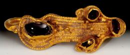 ARQUEOLOGÍA. VISIGODOS. Fíbula (IV-VII d.C.). Oro con granate. Longitud 4 cm.