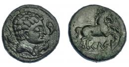 77 - HISPANIA ANTIGUA. KELSE. Semis. A/ Cabeza masculina con cuello vestido a der., alrededor tres delfines. R/ Caballo con rienda suelta a der., debajo KeLSE. AE 9,24 g. 22,8 mm. I-783. ACIP-1485. Pátina verde oscuro. MBC+. Rarísima.