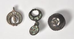 ROMA. Bajo Imperio. Lote de 3 apliques y/o fíbulas tardorromanos, formas redondeadas y decoración en pasta vítrea polícroma. Bronce con esmalte. Longitud 2,8 cm, 4,5 cm y  3,3 cm.