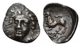 GRECIA ANTIGUA. CAMPANIA. Phistelia. Óbolo (c. 380-350 a.C.). A/ Cabeza frontal de ninfa. R/ León a izq., debajo serpiente. AR 0,46 g. 10,11 mm. COP-577 vte. SBG-No. Roturas al borde. MBC. Ex colección Guadán, 1340.
