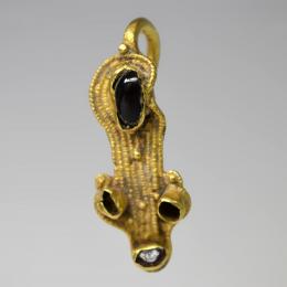 PUEBLOS GERMÁNICOS. Período visigodo. Fíbula (ss. IV-VII d.C.). Oro con granate. Longitud 4 cm.