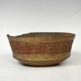 PREHISPÁNICO. Cuenco decorado con relieves antropomorfos y vegetales. Cultura Maya (período Clásico Tardío 600-1000 d. C.). Cerámica. Conserva restos de policromía. Reconstruido. Pérdidas en el borde y algunas grietas. Altura 6cm. Diámetro 15,8 cm.