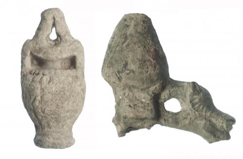 511 - ROMA. Imperio Romano. I-III d.C. Plomo y bronce. Lote de 2 objetos: una contrapesa en forma de ánfora y un aplique mobiliario, con orificio de sección cuadrangular y decoración distal con representación de lobo. Altura 6,1 y 7,3 cm.
