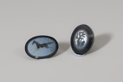 821   -  ROMA. Imperio Romano. Lote de dos entalles (I-II d.C.). Ágata azul. Uno con representación de caballo a galope a izquierda y otro con árbol. Altura 9 mm. Longitud 10 mm.