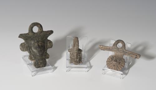 848   -  ROMA. Imperio Romano. Lote de tres apliques de asa de sítula (I-III d.C.). Bronce. Con representación frontal masculina barbada. Altura 5,2-8,2 cm.