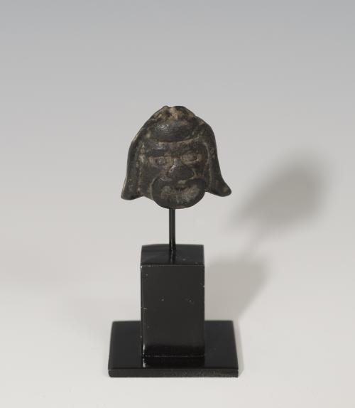 850   -  ROMA. Imperio Romano. Aplique (II-III d.C.). Bronce. Con representación de máscara teatral. Soldado a la peana. Altura 3,1 cm.