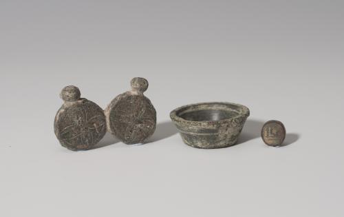 869   -  PERÍODO MEDIEVAL CRISTIANO Y ÁRABE. Lote de tres objetos (X-XV d.C.). Bronce.  Ponderal de medio dinar (1,78gr.) con la palabra 