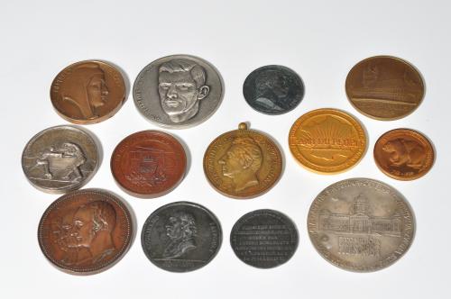 394 - Lote de 13 medallas y placas de diferentes países y metales. Siglos XIX-XX. De MBC a SC.