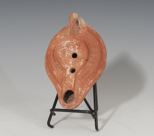 465 - ROMA. Imperio Romano. Lucerna (Finales IV d.C.). Terracota. Piquera circular, dos agujeros de llenado y disco circular decorado con motivo floral. Longitud 13,5 cm.