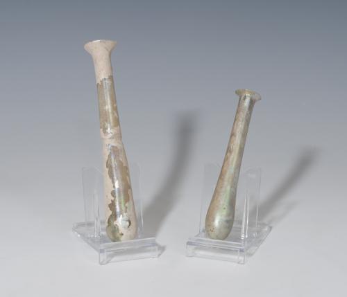 467 - ROMA. Imperio Romano. Lote de dos ungüentarios tubulares (I-IV d.C.). Vidrio. Altura 10,3 y 13,3 cm. Presentan irisaciones, exfoliafiones y alteraciones cromáticas.