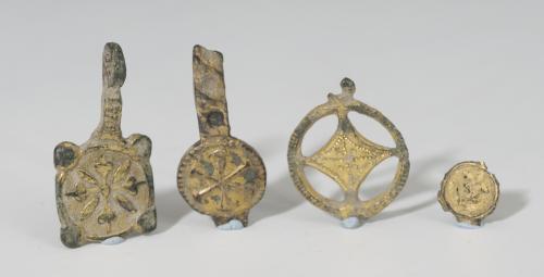 483   -  VISIGODO. Lote de cuatro colgantes y/o apliques (VI-VI d.C.). Bronce dorado. Con decoración esquemática, vegetal y crismón. Altura 1,0-3,2 cm.