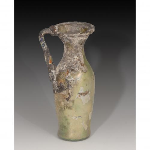 2700 - ROMA. Imperio Romano. Jarrita (IV d.C.). Vidrio. Altura 12,3 cm. Presenta irisaciones y alteraciones cromáticas.