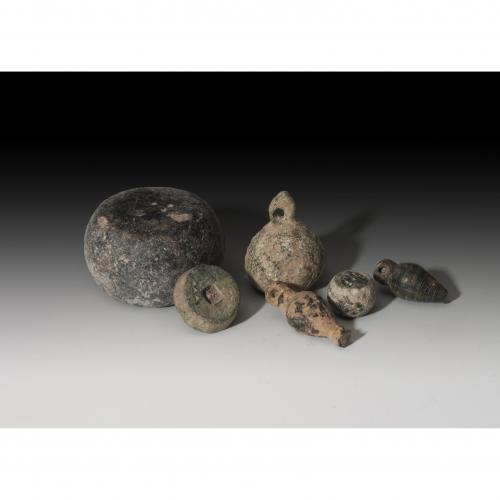 2723 - ROMA. Imperio Romano. Lote de seis objetos (I-IV d.C.). Bronce y piedra pulimentada. Dos colgantes en forma de bellota, cuatro ponderales: con orificio cuadrangular central, otro epigrafíado con IOB, otro con arandela superior y otro pulimentado. Altura 0,6-3,0 cm. Diámetro 1,3-3,5 cm.