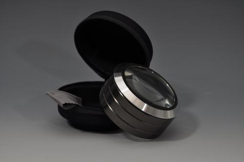 511 - Lupa de pie con luz blanca LED, marca LINDNER. Aumento 5x. Encuadre de 60 mm. aprox. Incluye un estuche negro y acolchado, con diámetro de 105 mm de diámetro y 70 mm de altura, un paño para limpiar y pilas. Marco del lento de aluminio; carcasa negra de metal; vidrio óptico.