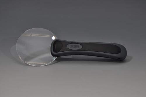 512 - Lupa sin marco, marca LINDNER. Con mango. Aumento 3x. Encuadre de 75 mm. Incluye funda de tela para protección de la lupa.