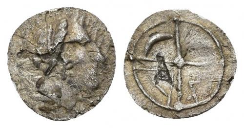 3034 - HISPANIA ANTIGUA. Divisores de imitación masaliota. Tritartemorion. A/ Cabeza femenina a der. R/ Rueda de 4 radios, en los cuarteles creciente, M y A. AR 0,43 g. 10,3 mm. ACIP-482. CC-993, mismo ejemplar. Erosiones. BC+. Muy rara. Ex colección Cores.