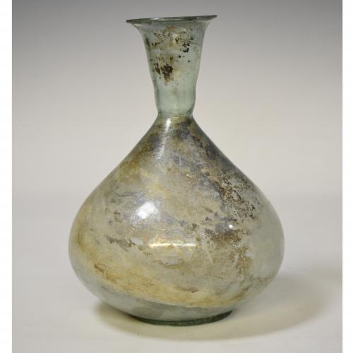2060   -  ROMA. Imperio Romano. Botella globular (ss. II-IV d.C.), con cuello troncocónico y boca exvasada. Vidrio. Presenta irisaciones. Altura 17,5 cm. 