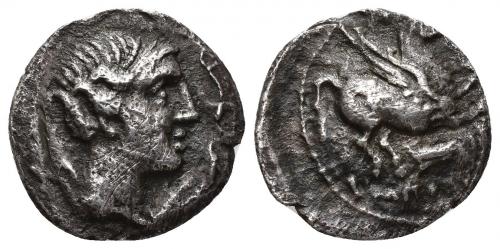 38 - HISPANIA ANTIGUA. EMPORION. Dracma. A/ Cabeza femenina a der. con tocado vegetal, rodeada por tres delfines. R/ Pegaso volando a der., debajo símbolo proa y encima P, ley. EMPORITWN. AR 3,70 g. 18,1 mm. I-1128. ACIP-235. CC-127, mismo ejemplar. Porosidades y rayitas en rev. Rev. descentrado. MBC. Muy rara.