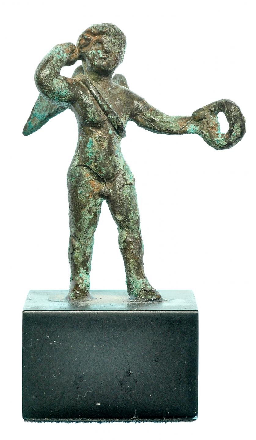 719   -  ROMA. Imperio Romano. Bronce. Figura exenta de Cupido con carcaj y corona de laurel. Alura: 5,1 cm. Incluye peana. Procedente de colección privada española años 2000.