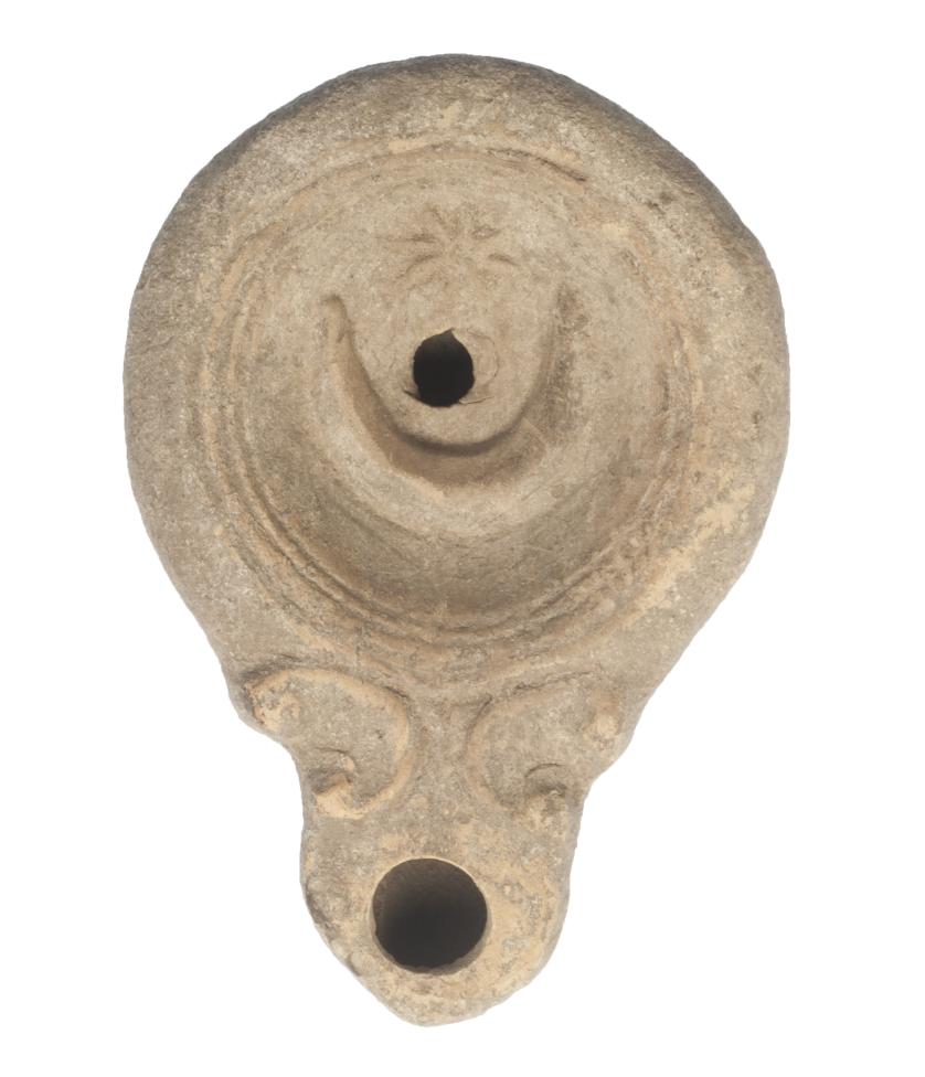 490   -  ROMA. Imperio Romano. I d.C. Terracota. Lucerna de pasta grisácea, piquera cónica y agujero central de llenado. Disco central decorado con estrella y media luna. Longitud 9,8 cm.