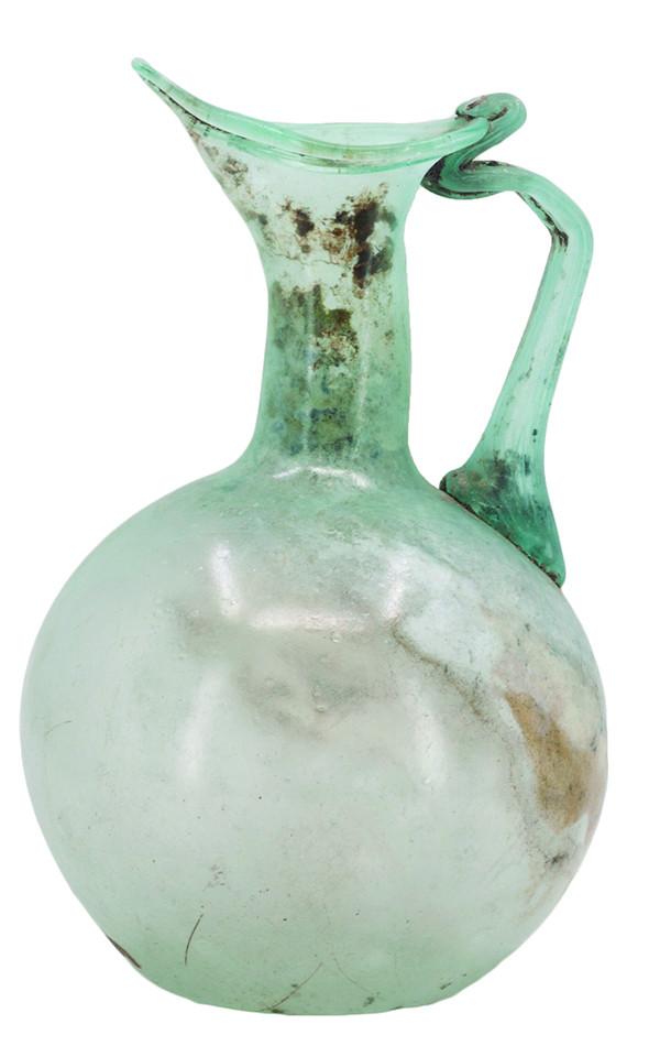2058   -  ROMA. Imperio Romano. Jarra (II d.C.). Vidrio transparente azulado. Altura 13,1 cm. Presenta irisaciones. 