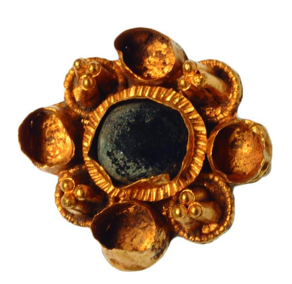 2083   -  CULTURA GODA. VISIGODO. Aplique (VII-VIII d.C.). Oro. Con decoración de piedra central de color azul oscuro y espacios laterales huecos. Entre ellos, decoración con técnica de granulado. Diámetro 22 mm.