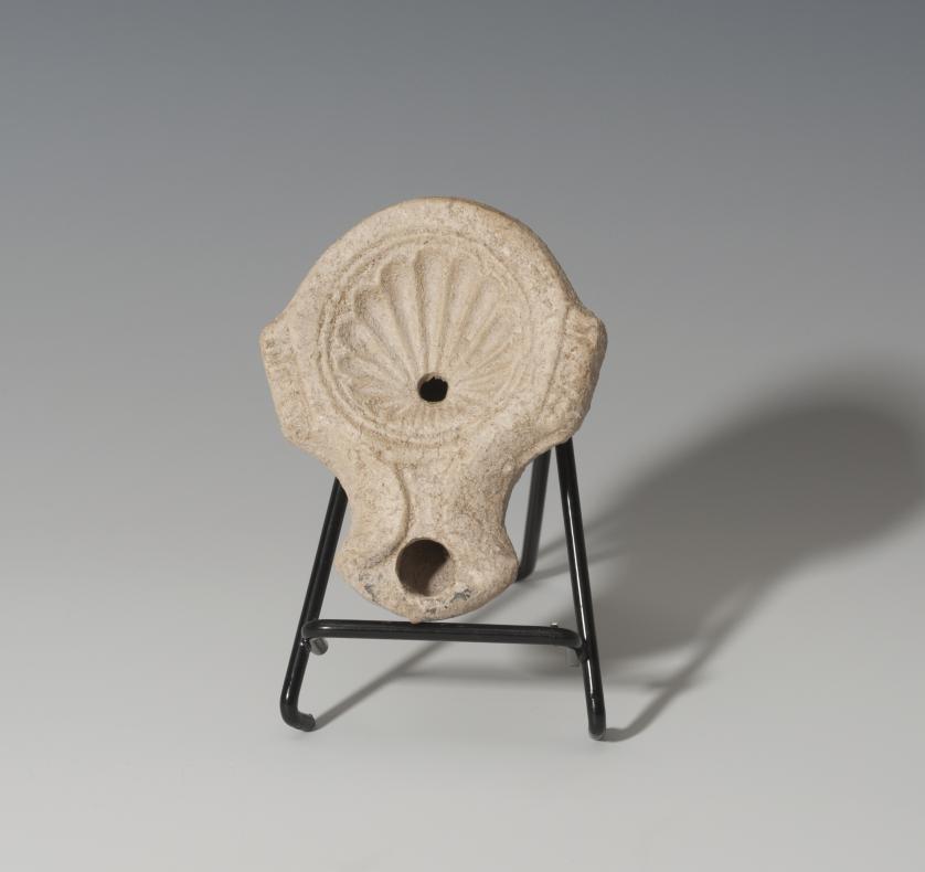 828   -  ROMA. Imperio Romano. Lucerna (I-II d.C.). Terracota. Con decoración de concha en disco central y un agujero de llenado. Longitud 9,8 cm. 