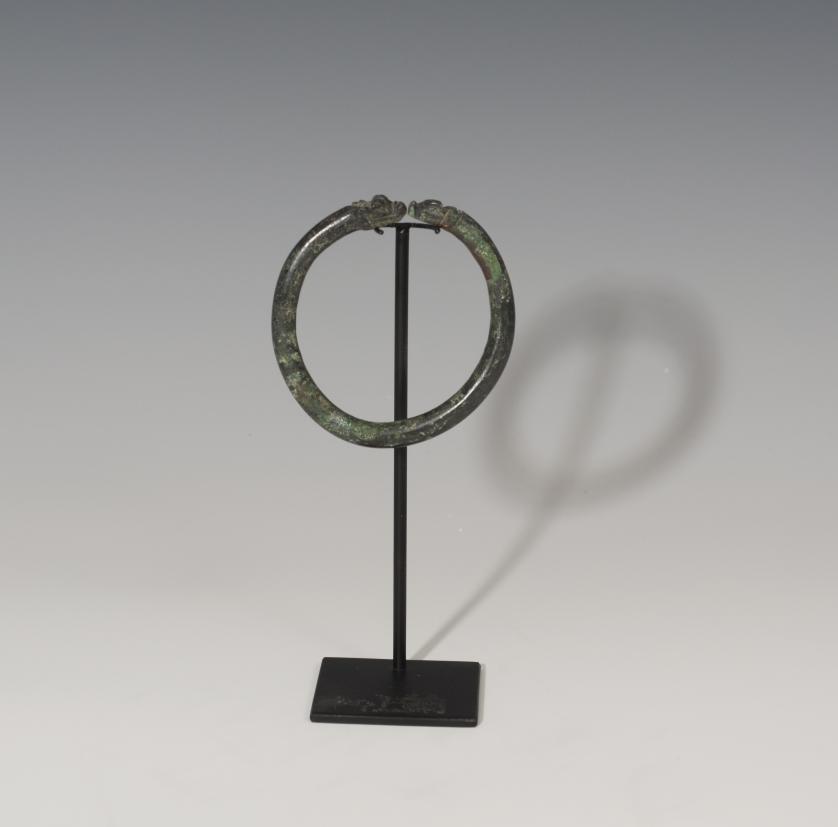 854   -  ROMA. Imperio Romano. Brazalete (III-IV d.C.). Bronce. Con apéndices zoomorfos. Altura 7,4 cm. Diámetro interior 5,8 cm.