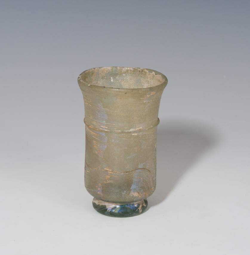 470   -  ROMA. Imperio Romano. Vaso (IV-V d.C.). Vidrio. Altura 9,9 cm. Diámetro 6,4 cm. Presenta irisaciones. 