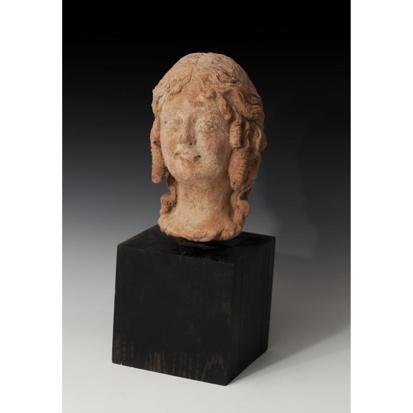 2660   -  GRECIA. Período helenistico. Cabeza femenina (III-II a.C.). Terracota. Dimensiones 25,5 x 10,0 cm. Incluye peana