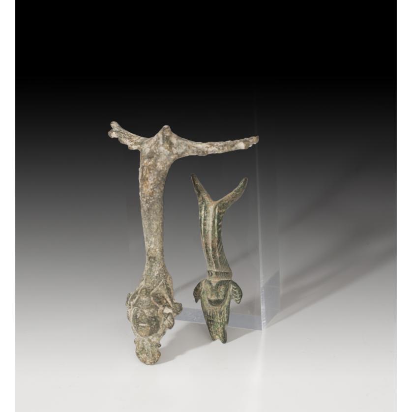 2714   -  ROMA. Lote de dos asas de jarra (I a.C. - IV d.C.). Bronce. Una con decoración distal cefaliforme y otra zoomorfa. Altura 5,8 y 7,9 cm.