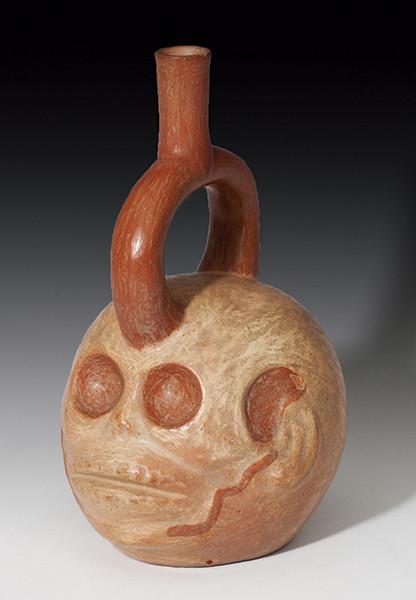 2052   -  PREHISPÁNICO. Cultura Moche. Botella gollete con asa estribo (400-800 d.C.). Cerámica policromada. Con representación de calavera. Altura 23,5 cm. Presenta prueba de termoluminiscencia.