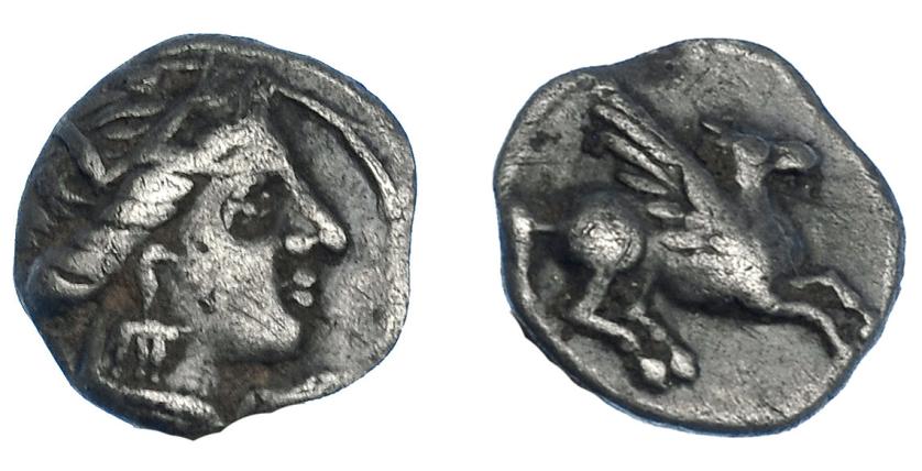 105   -  HISPANIA ANTIGUA. EMPORION. Divisores anteriores a las dracmas. Tritartemorion. A/ Cabeza femenina con tocado vegetal a der., entre E y M (no visibles). R/ Pegaso volando a der. AR 0,55 g. 8,1 mm. ACIP-180. CC-72, mismo ejemplar. MBC.