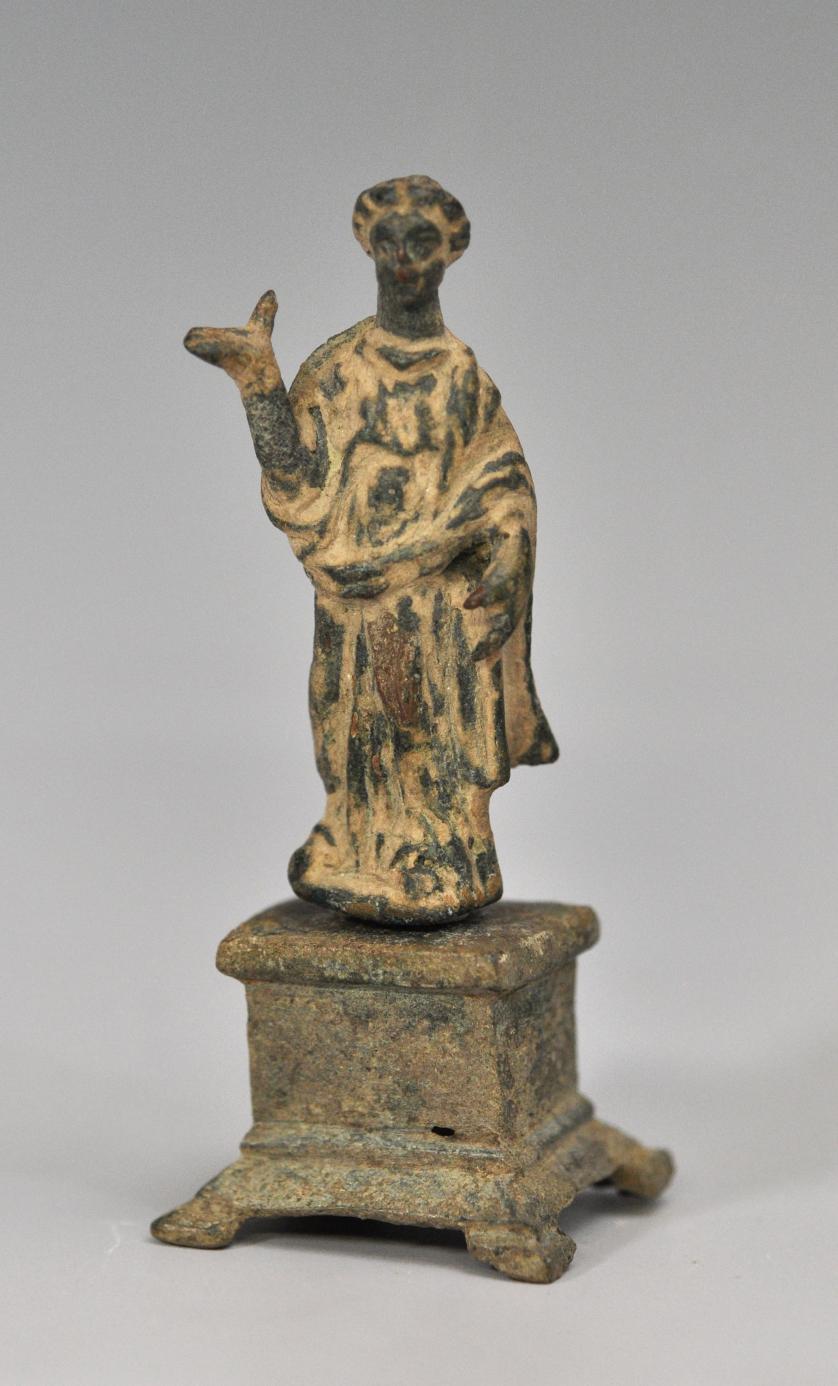 2015   -  ARQUEOLOGÍA. ROMA. Imperio Romano. Figura femenina (s. II d.C), con mano derecha levantada, sobre pedestal. Bronce. Altura 7,5 cm.