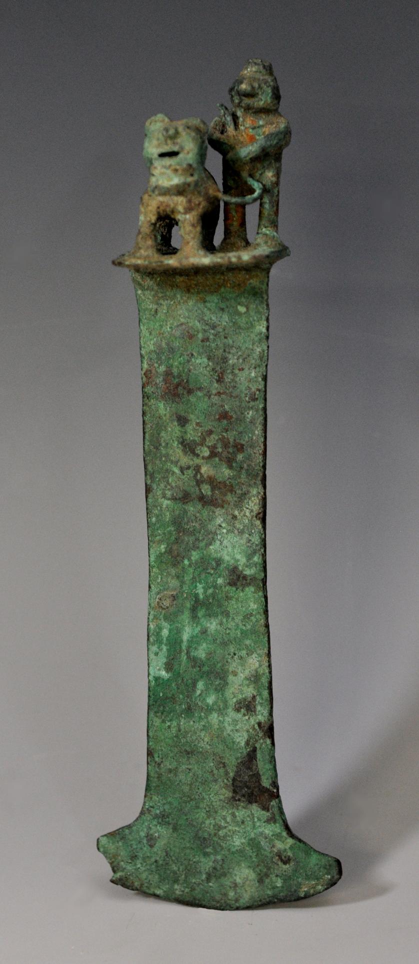 2064   -  ARQUEOLOGÍA. PREHISPÁNICO. Tumi con guerrero y una fiera atada. Cultura Moche (150-700 d. C.). Bronce. Longitud 18 cm.
