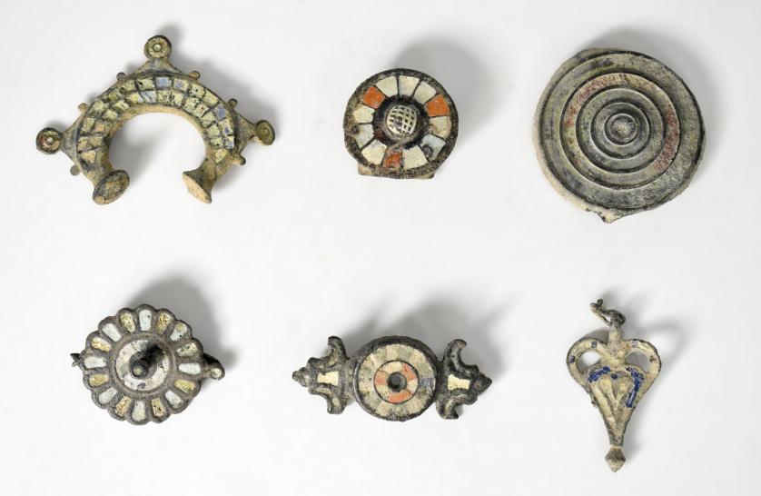2071 - ROMA. Bajo Imperio. Lote de 6 bronces tardorromanos: tres apliques, dos fíbulas y un colgante, con decoraciones en pasta vítrea (s. V d.C.). Bronce con esmalte. Longitud de 3,3 a 7 cm.
