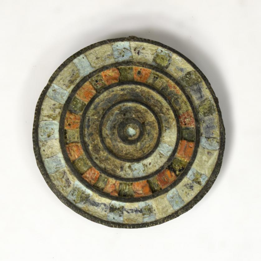 2074   -  ROMA. Imperio Romano. Aplique con decoración polícroma (ss. III-IV d.C.). Bronce con esmalte. Restos de pegamento en el reverso. Diámetro 4,4 cm. 