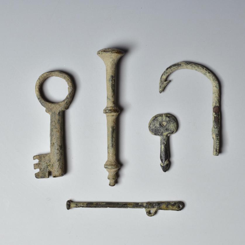 2012   -  ARQUEOLOGÍA. ROMA. Imperio Romano. Lote de 5 objetos: un bocado de caballo, dos llaves, un anzuelo y un objeto alargado (I-IV d.C.). Bronce y plomo. Longitud de 3 cm a 6,4 cm.
