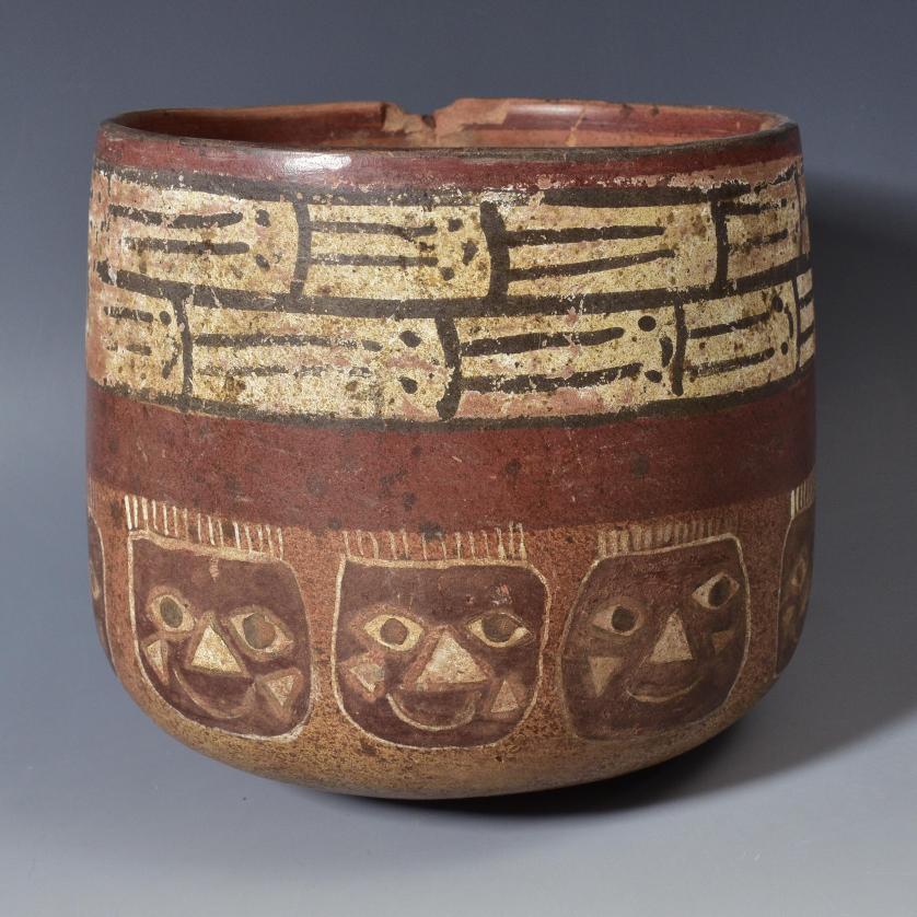 2038   -  ARQUEOLOGÍA. PREHISPÁNICO. Vaso con máscaras y decoración geométrica. Cultura Nazca (100 - 800 d.C.). Parcialmente reconstruido y algunas pérdidas en los bordes.  Cerámica policromada. Altura 12 x 11,5 cm. 