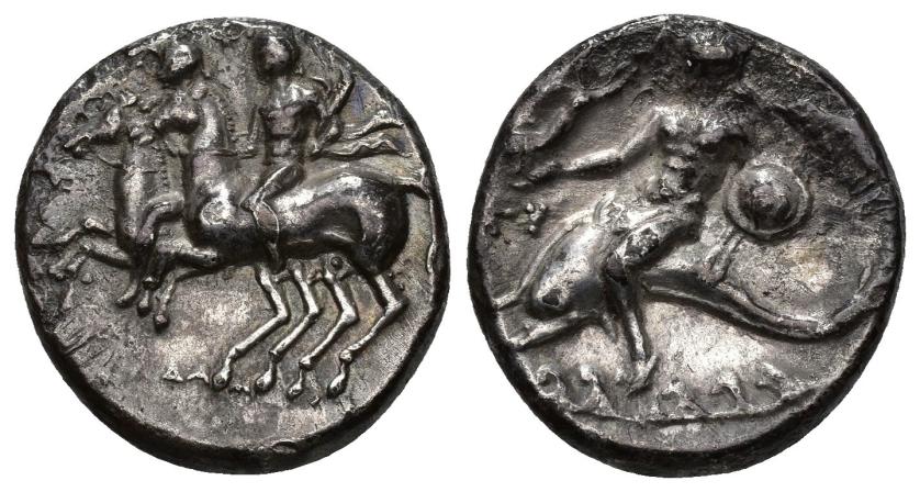 16   -  GRECIA ANTIGUA. CALABRIA. TARENTO. Didracma (281-240 a.C.). A/ Dioscuros cabalgando a izq., encima F, debajo (S)ODA(MOS). R/ Taras cabalgando delfín a izq. con escudo y lanzas y coroando por Niké volando frente a él, en campo U, detrás TARAS no visible. AR 6,10 g. 20,1 mm. COP-830 vte. SBG-371 vte. Erosiones. MBC+.