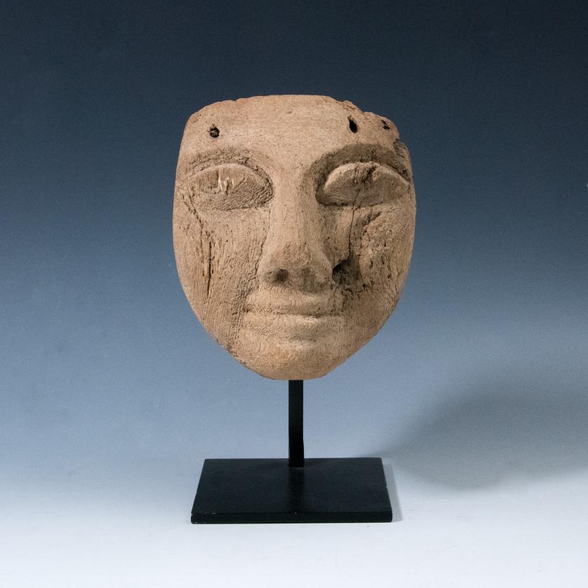 2002   -  ARQUEOLOGÍA. ANTIGUO EGIPTO. Baja Época. Máscara funeraria. Siglos VI-IV a.C. Madera. Incluye soporte. Altura 14 cm.