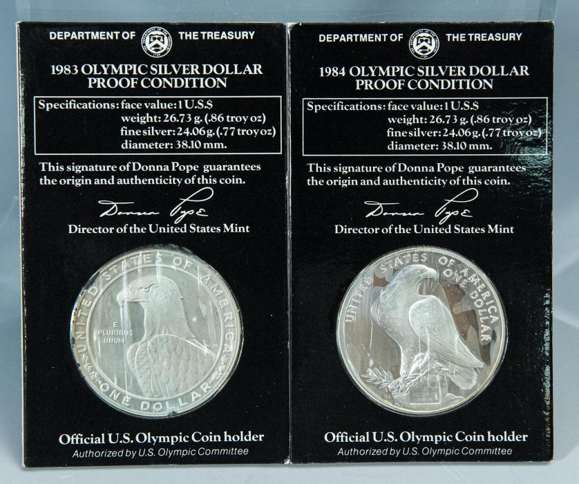 633   -  MONEDAS EXTRANJERAS. ESTADO UNIDOS DE AMÉRICA. Lote de 2 monedas conmemorativas de los juegos olímpicos de 1983 y 1984. Dentro de su embalaje original con nº de serie. Prueba.