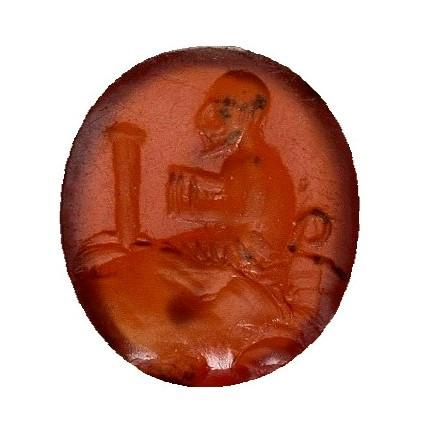 2056   -  ARQUEOLOGÍA. ROMA. Imperio Romano. Entalle con figura arrodillada a izq. con columna delante (ss. I- II d.C.). Cornalina. Diámetro 0,8 cm.